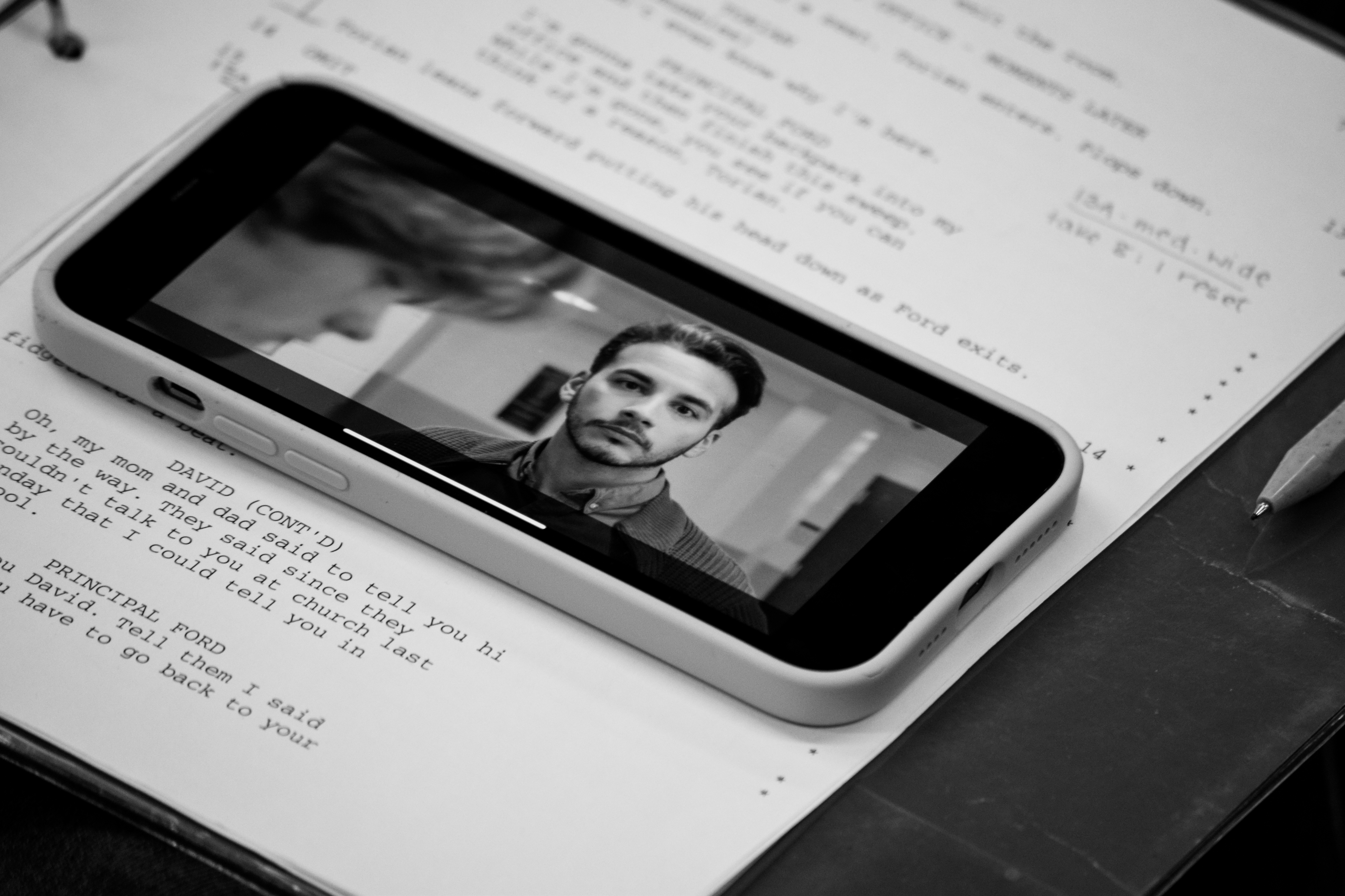 Screenwriter reviewing a script with a phone